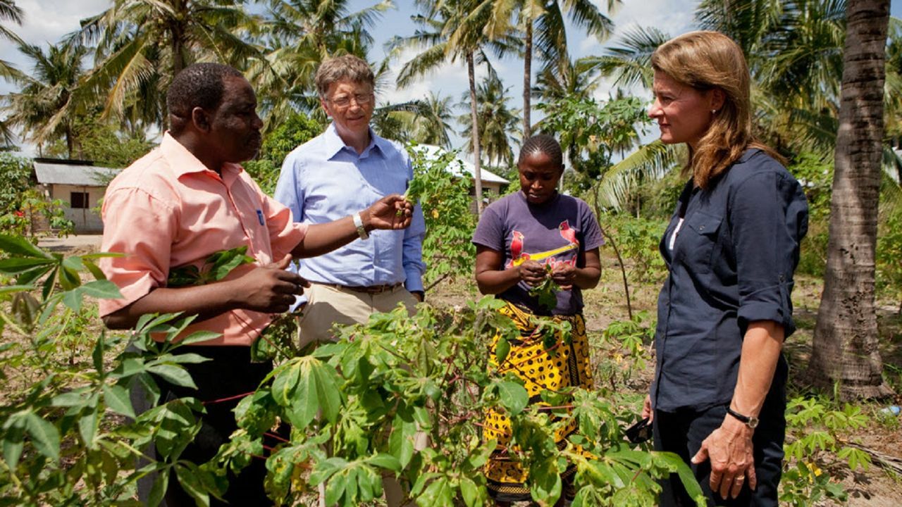 Bill und Melinda Gates, die sich mit einer Person mit dunkler Hautfarbe unterhalten.